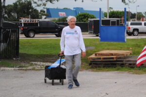 Matthew Montavon wearing a Matthew Montavon for Congress shirt and pulling a wagon containing a Matthew Montavon for Congress sign.
